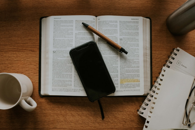 black smartphone on white notebook — Foto por Nicolas Lobos na Unsplash