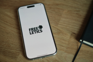 A cell phone sitting on top of a wooden table — Foto por appshunter.io na Unsplash