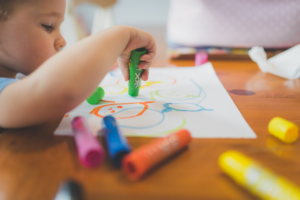 a little boy that is sitting at a table with some crayons — Foto por Stephen Andrews na Unsplash