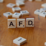 A wooden table topped with scrabble tiles spelling the word afd — Foto por Markus Winkler na Unsplash